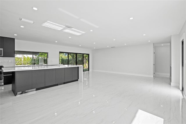 living area with recessed lighting, marble finish floor, and baseboards