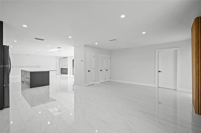 empty room featuring recessed lighting, visible vents, marble finish floor, and baseboards