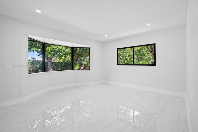 empty room featuring recessed lighting and baseboards