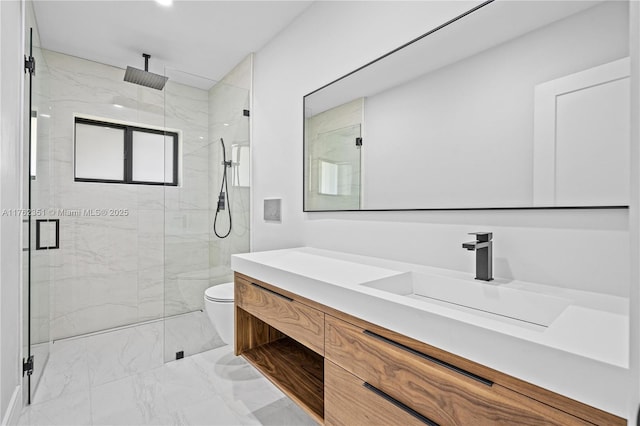 bathroom with vanity, toilet, marble finish floor, and a marble finish shower