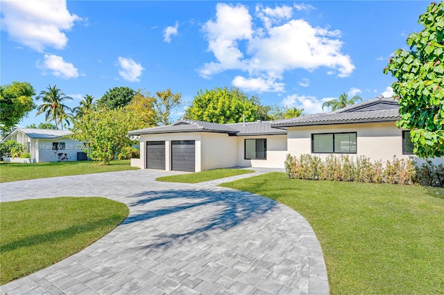 single story home with decorative driveway, a front lawn, a tiled roof, and an attached garage