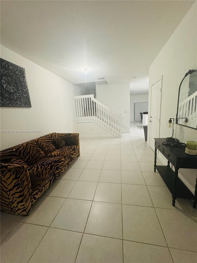 corridor featuring light tile patterned floors and an upstairs landing