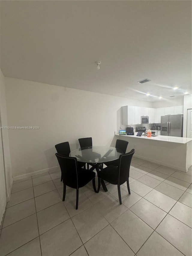 dining area with visible vents, baseboards, and light tile patterned flooring