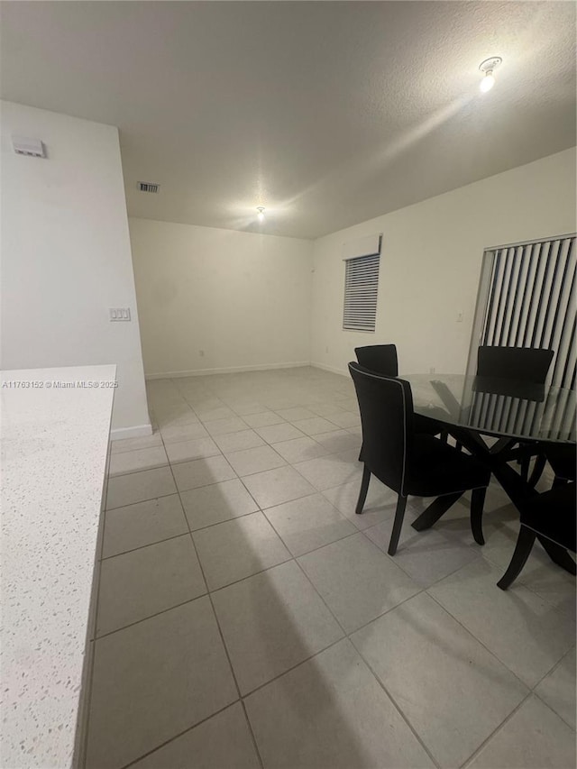 dining space with light tile patterned floors, visible vents, and baseboards