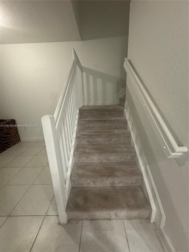 stairway with tile patterned flooring and baseboards