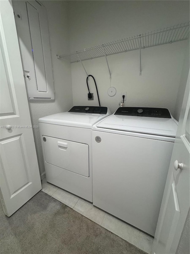 laundry area featuring washer and clothes dryer, laundry area, and light tile patterned flooring