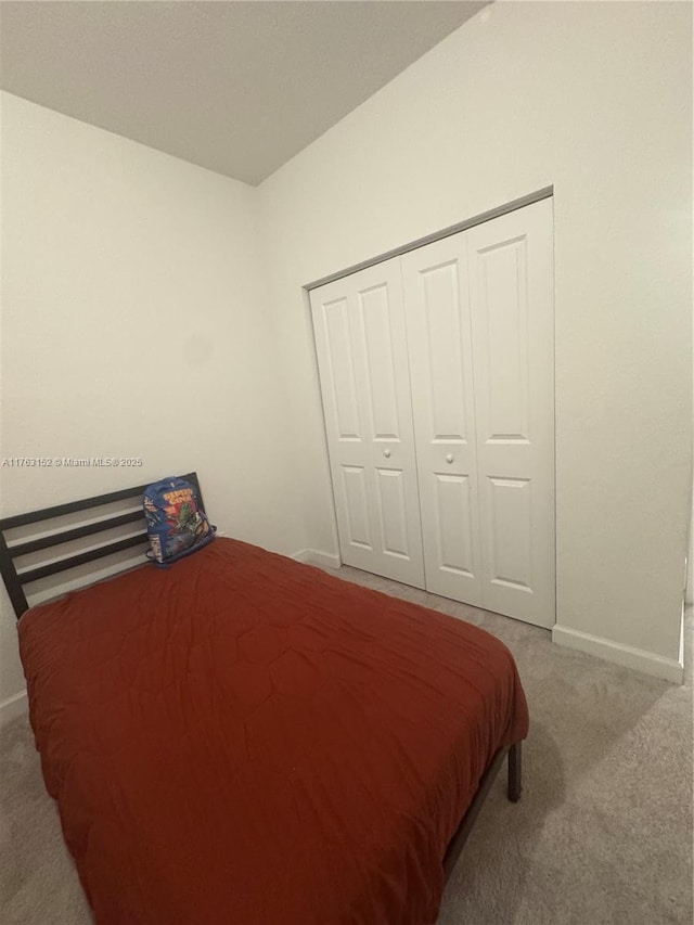 bedroom featuring carpet flooring, baseboards, and a closet