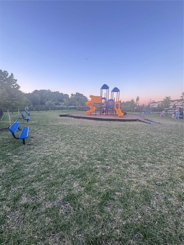 community play area with a lawn and fence