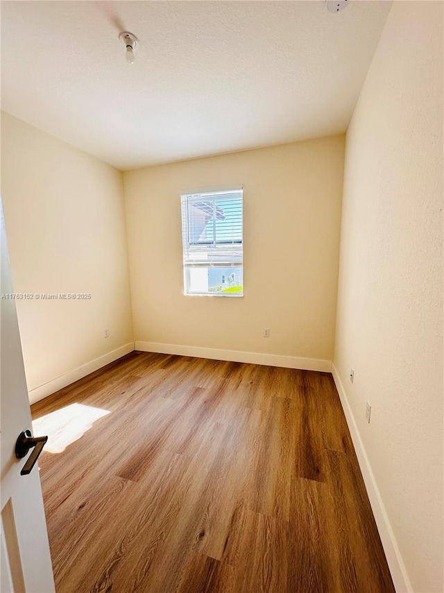 unfurnished room featuring baseboards and wood finished floors