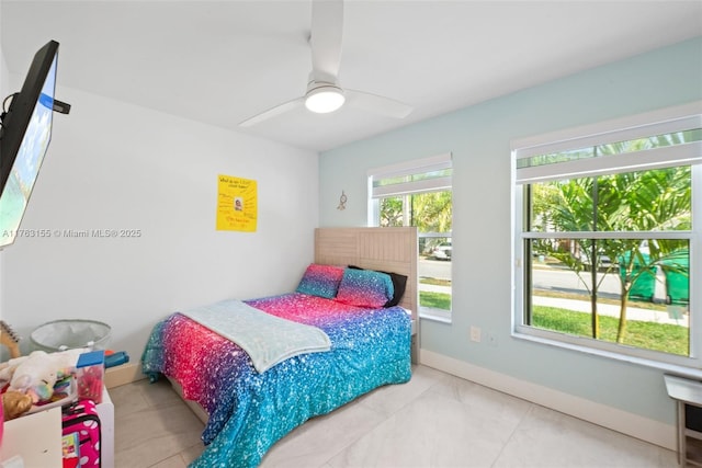 bedroom featuring tile patterned floors, baseboards, and a ceiling fan