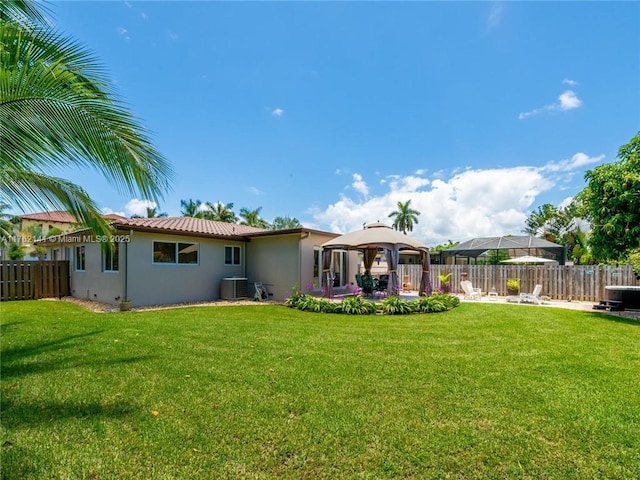 back of house featuring stucco siding, a lawn, a patio, fence, and a gazebo