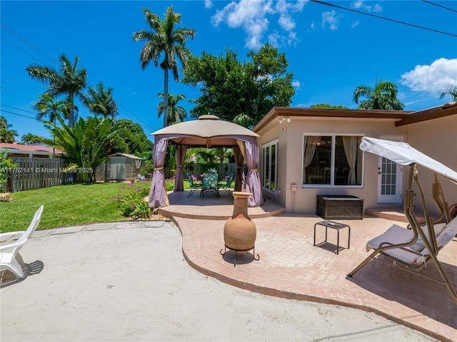 view of patio featuring a gazebo, an outbuilding, fence, and a shed