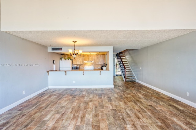 1548 NW 113th Way, Pembroke Pines, FL 33026 - living room with a textured ceiling, visible vents, a chandelier, wood finished floors, and stairway