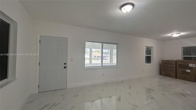 interior space with baseboards and marble finish floor