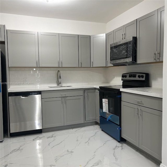 kitchen featuring black / electric stove, a sink, gray cabinetry, dishwasher, and tasteful backsplash