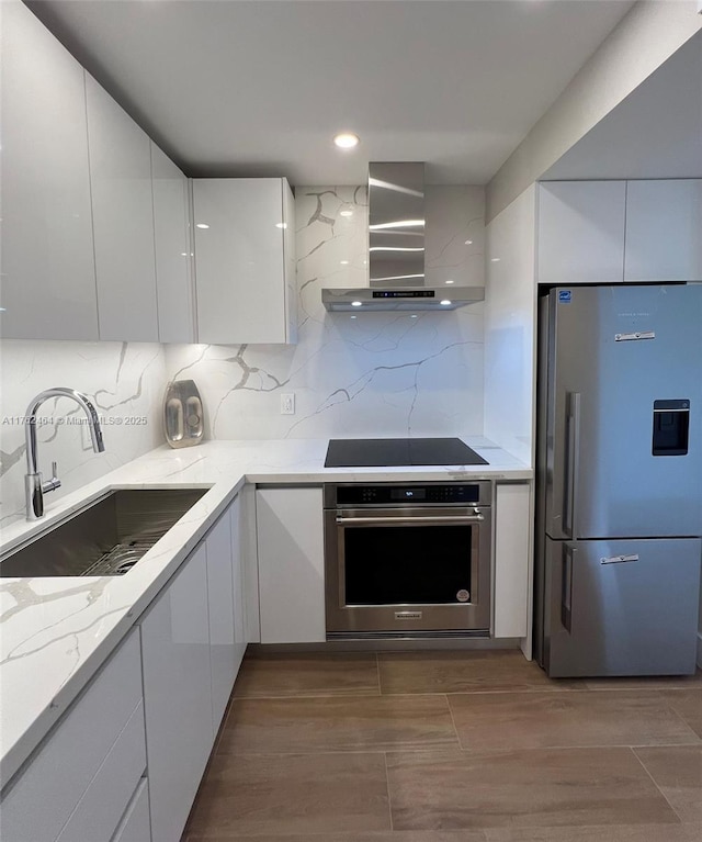 1881 Middle River Dr Unit 207, Fort Lauderdale, FL 33305 - kitchen with modern cabinets, wall chimney exhaust hood, a sink, and stainless steel appliances