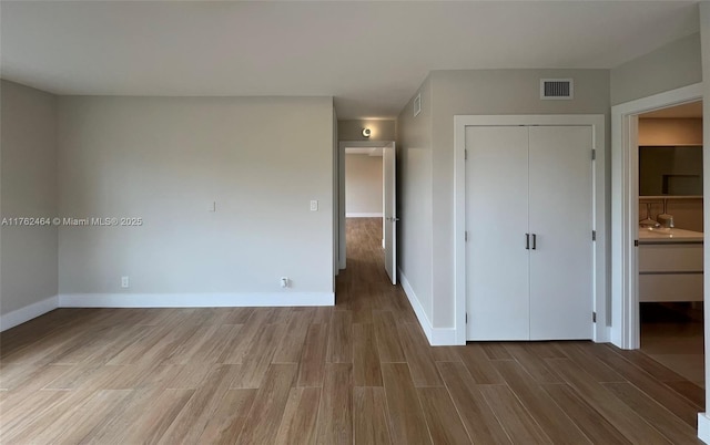 1881 Middle River Dr Unit 207, Fort Lauderdale, FL 33305 - unfurnished bedroom with a closet, baseboards, visible vents, and wood finished floors