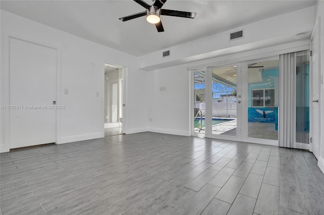 unfurnished room with visible vents, baseboards, ceiling fan, and wood finished floors