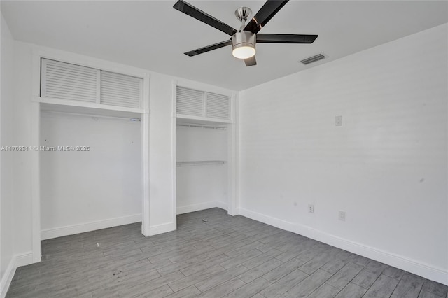 unfurnished bedroom with visible vents, baseboards, wood finished floors, and a ceiling fan