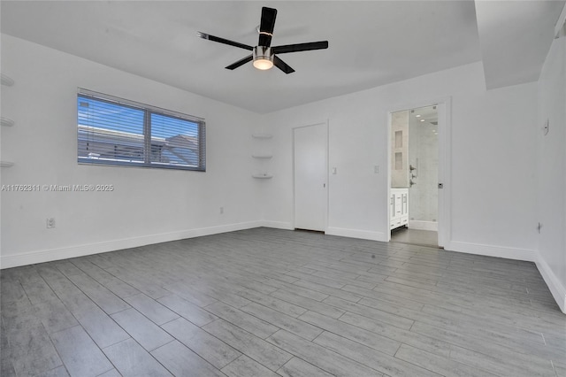 empty room featuring ceiling fan, baseboards, and wood finished floors