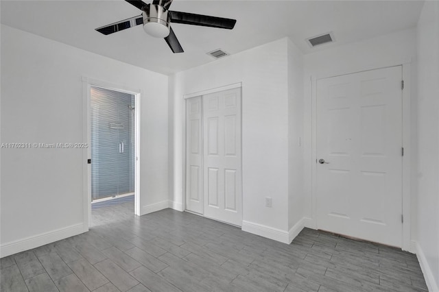 unfurnished bedroom with visible vents, baseboards, a closet, and wood tiled floor