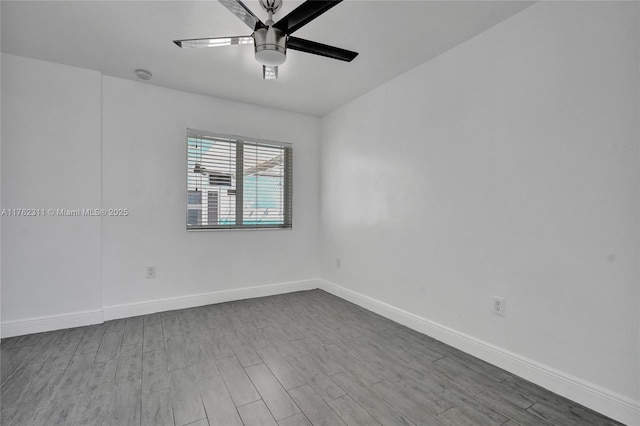 spare room with a ceiling fan, wood finished floors, and baseboards