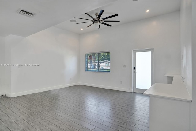 unfurnished living room featuring visible vents, a ceiling fan, wood finished floors, recessed lighting, and baseboards