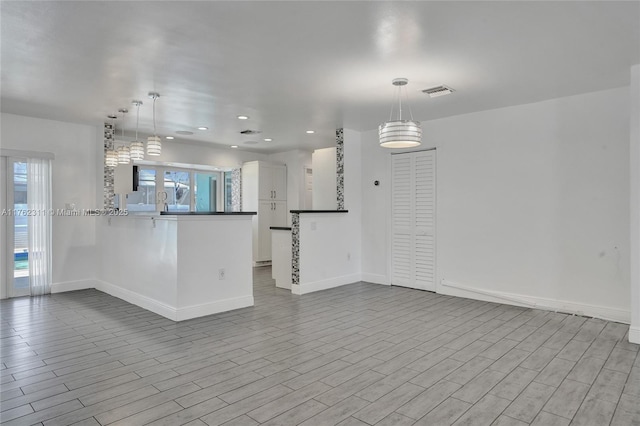 unfurnished living room with recessed lighting, baseboards, plenty of natural light, and wood finished floors