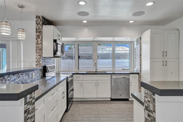 kitchen featuring dark countertops, tasteful backsplash, wood tiled floor, stainless steel appliances, and a sink