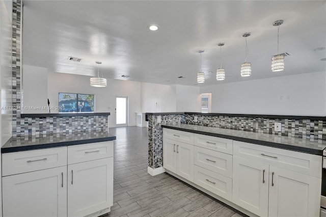 kitchen with dark countertops, visible vents, backsplash, and wood tiled floor