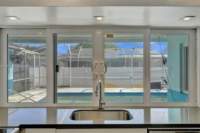 interior details with a sink, dark countertops, and dishwasher