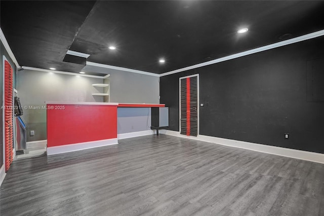 cinema room featuring wood finished floors, baseboards, and ornamental molding