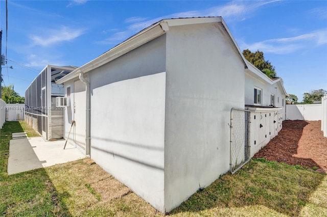 view of side of home with a lanai, stucco siding, a patio, and a fenced backyard