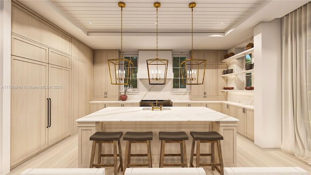 kitchen featuring a kitchen bar, open shelves, an island with sink, and a raised ceiling