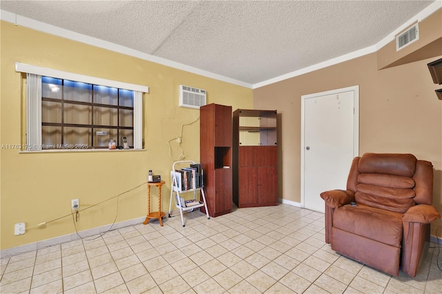 sitting room with visible vents, ornamental molding, a textured ceiling, a wall unit AC, and baseboards