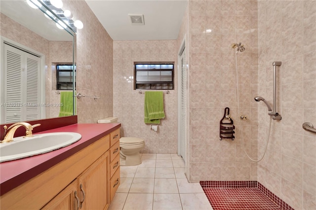 bathroom with vanity, visible vents, a tile shower, a closet, and tile patterned floors