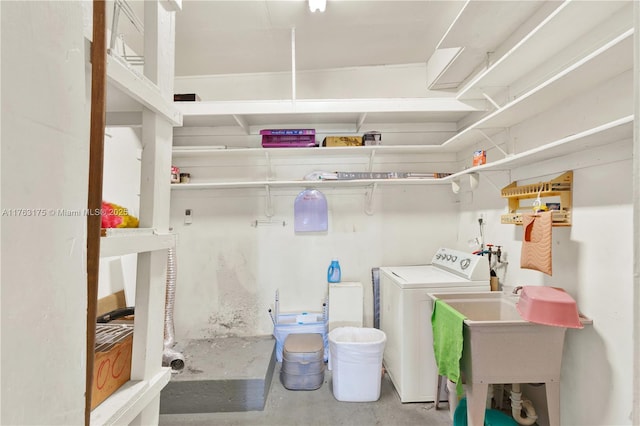 clothes washing area featuring a sink, washer / dryer, and laundry area