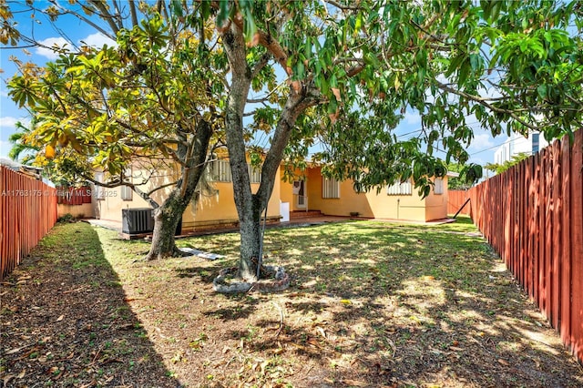 view of yard with central AC and a fenced backyard