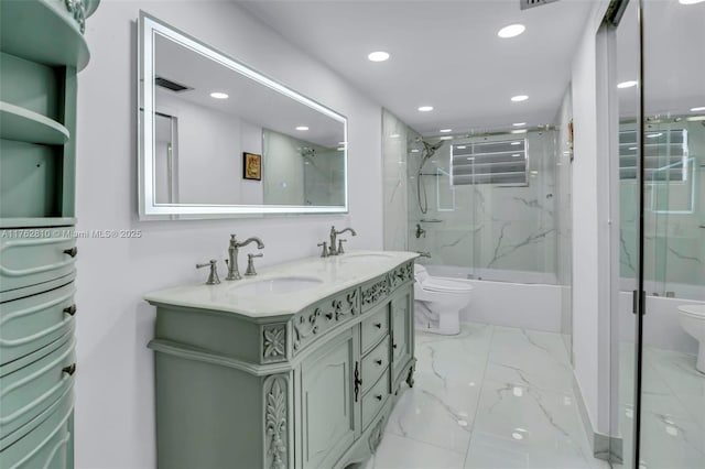 full bath with a sink, toilet, marble finish floor, and double vanity