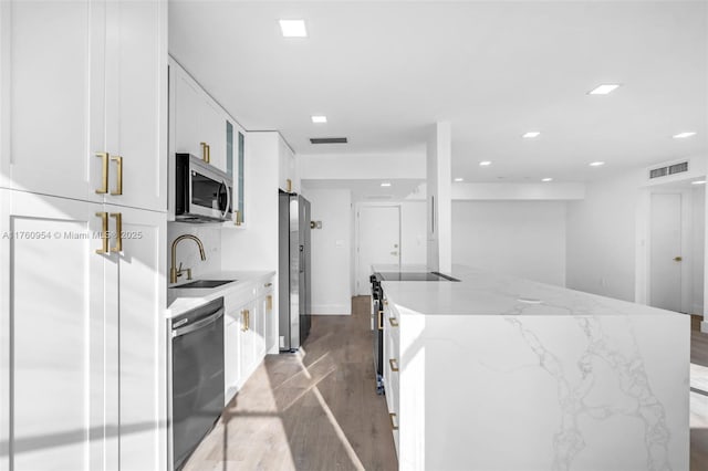 kitchen with a sink, stainless steel appliances, light wood-style floors, and visible vents