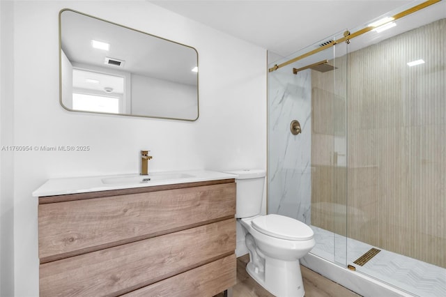 full bath with a marble finish shower, toilet, visible vents, and vanity