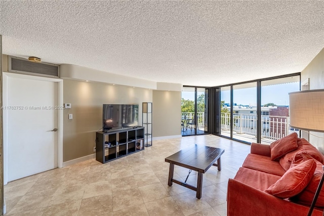 living room featuring a wall of windows, baseboards, visible vents, and a textured ceiling