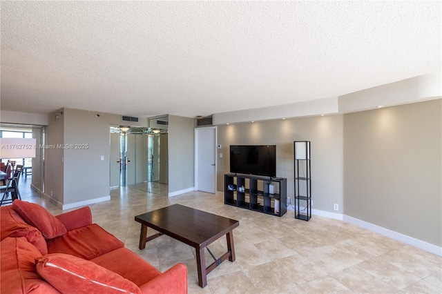 living room featuring visible vents, baseboards, a textured ceiling, and ceiling fan