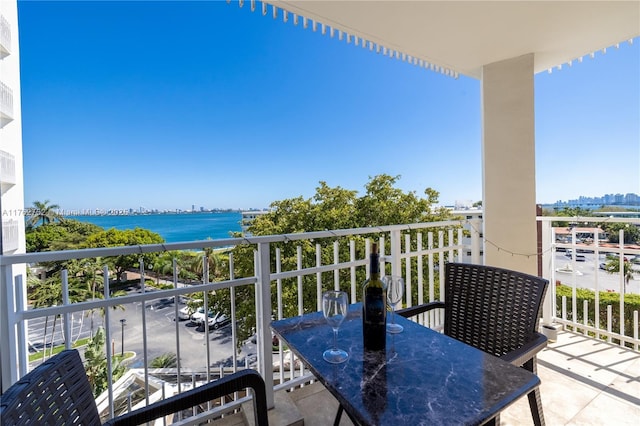 balcony featuring a water view and outdoor dining space