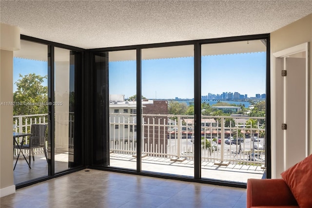 doorway featuring floor to ceiling windows, a view of city, and a healthy amount of sunlight