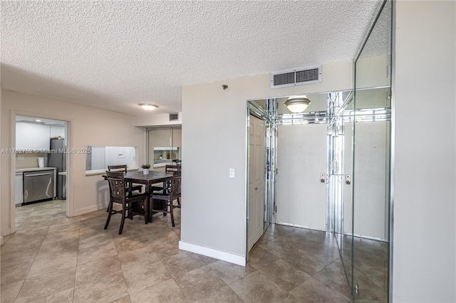 dining room featuring visible vents, baseboards, and a textured ceiling