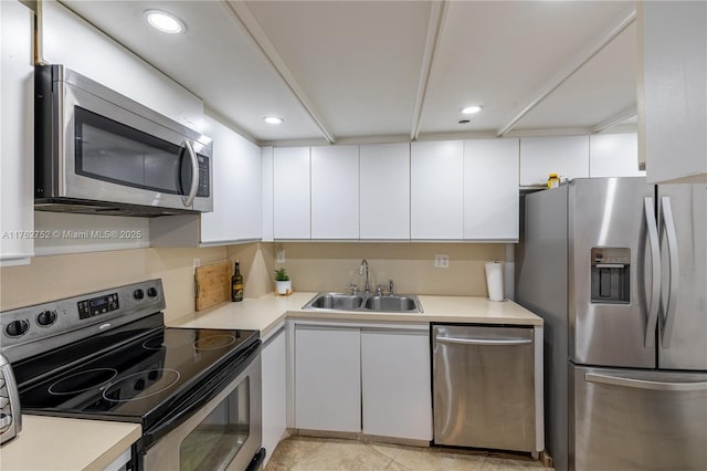 kitchen with light countertops, recessed lighting, appliances with stainless steel finishes, white cabinets, and a sink