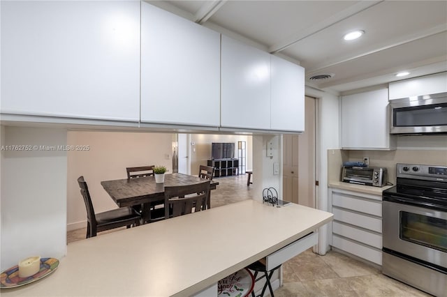 kitchen featuring visible vents, recessed lighting, light countertops, white cabinets, and appliances with stainless steel finishes