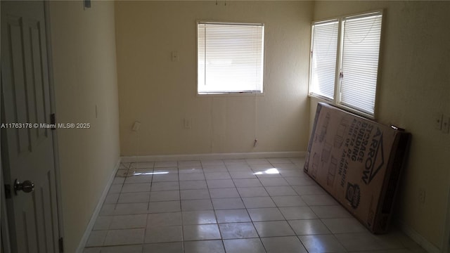 spare room featuring light tile patterned floors and baseboards