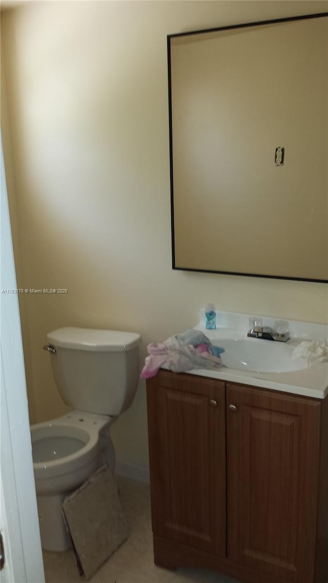 half bathroom with tile patterned floors, toilet, and vanity